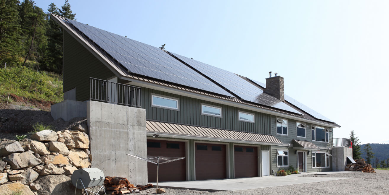 Keith Construction energy-efficient home in Vernon, BC, featuring solar panels, a sloped roof, and a three-car garage, designed for sustainability and modern living.