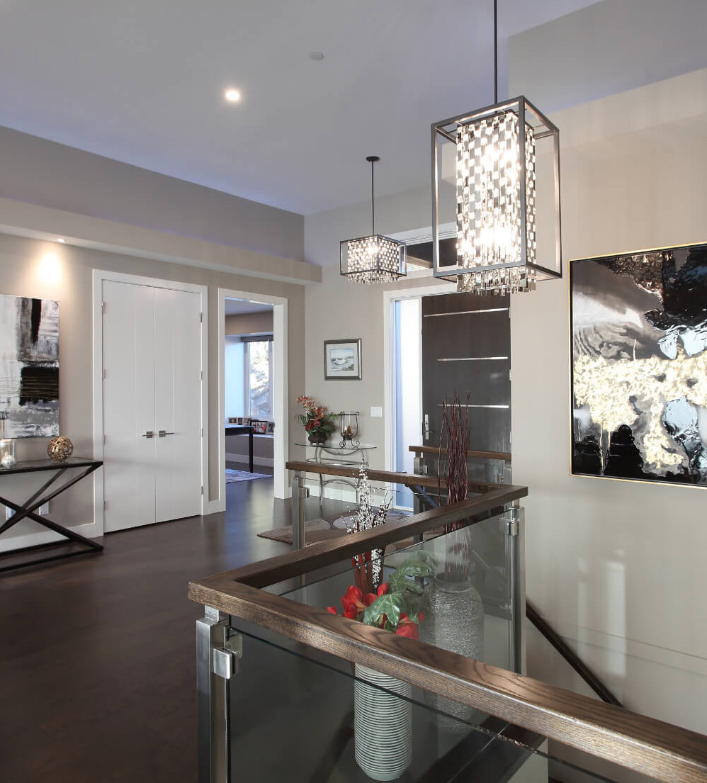 Keith Construction modern home entryway in Vernon, BC, featuring statement lighting, glass railing, and contemporary decor.
