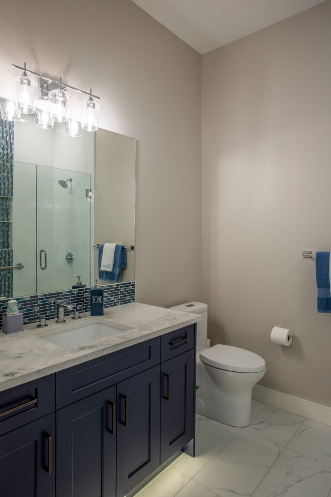 Photo of ensuite with dark wood cabinet and white/beige marble countertops.