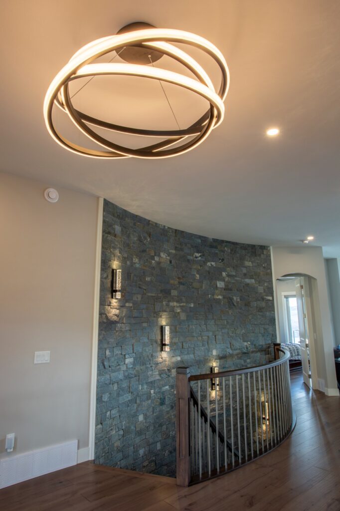 Photo of cultured stone accent stairwell with new age contemporary light fixture.