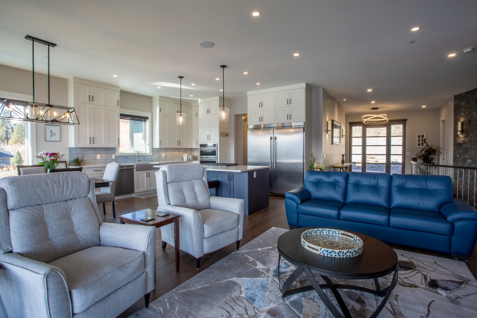 Modern custom home with wood and dark metal siding, large windows, and a spacious driveway, built by Keith Construction in Coldstream, BC.