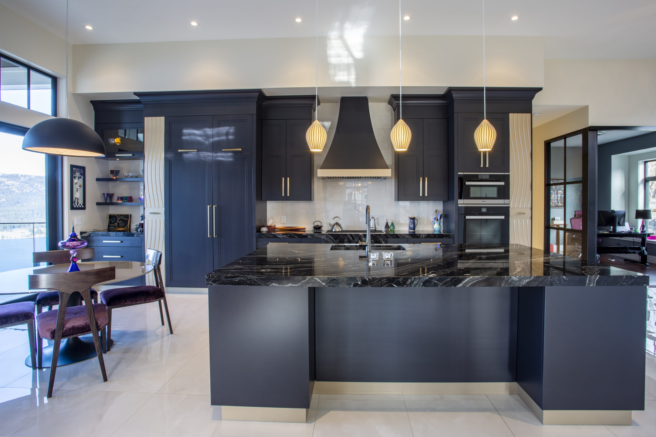 Modern custom home with wood and dark metal siding, large windows, and a spacious driveway, built by Keith Construction in Coldstream, BC.