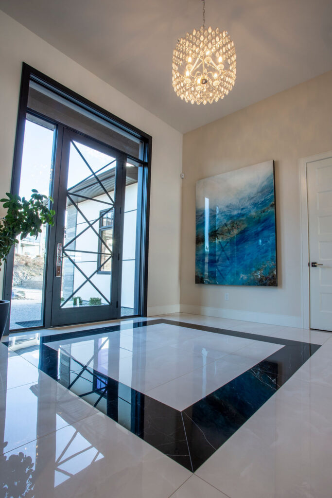 Photo of glass doored entry, with white marble flooring with black accent.