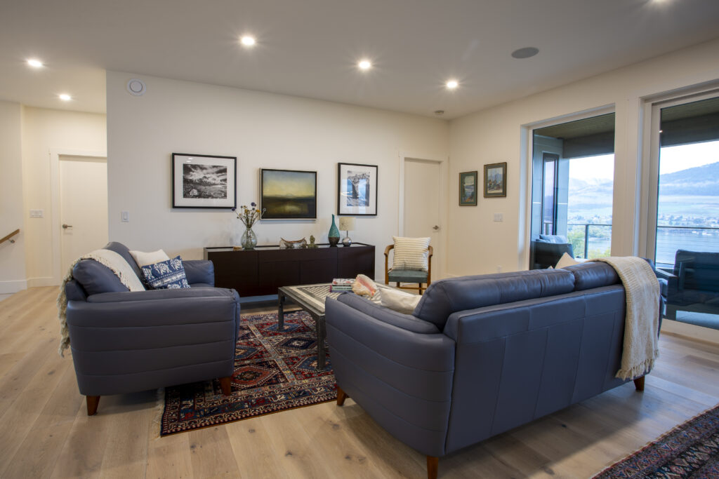 Living room with blue sofas, rug, and large sliding glass doors leading to a patio.
