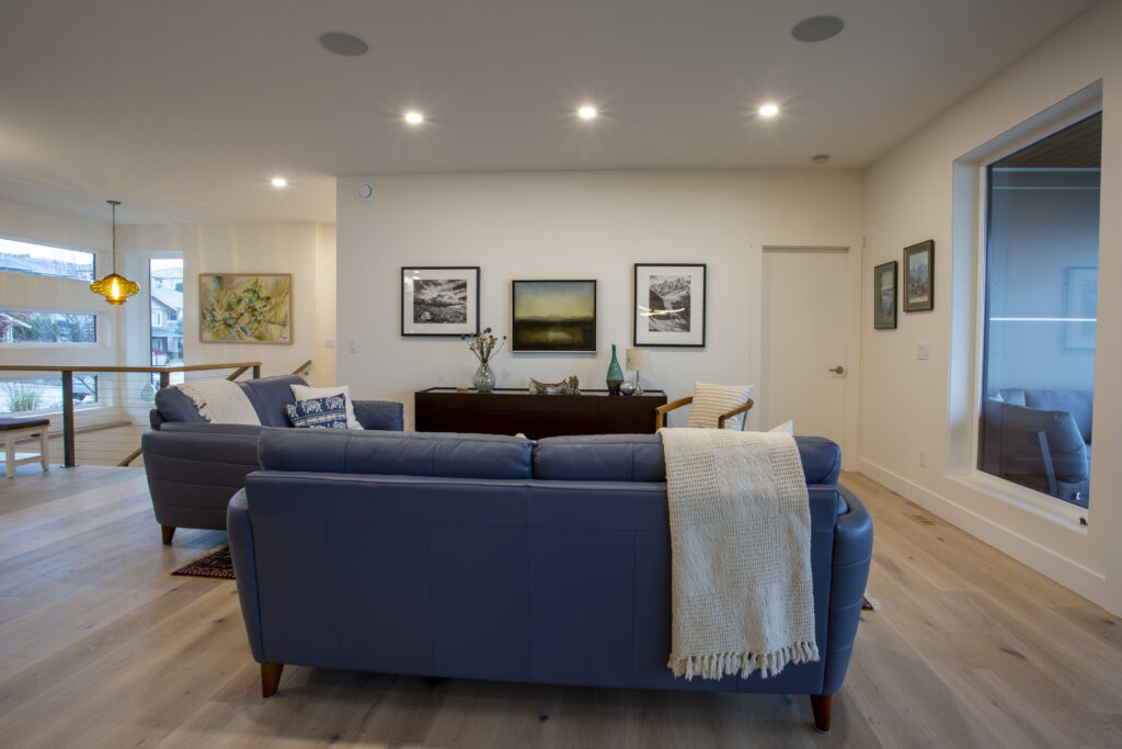 Living room with blue sofas, rug, and large sliding glass doors leading to a patio.