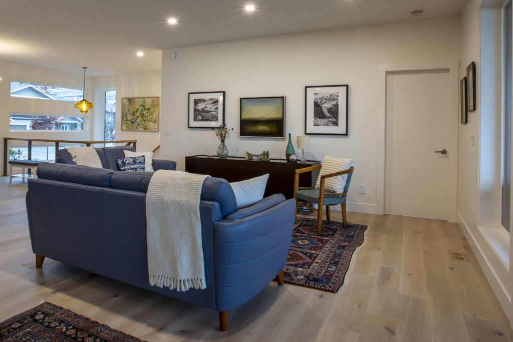 Living room with blue sofas, rug, and large sliding glass doors leading to a patio.