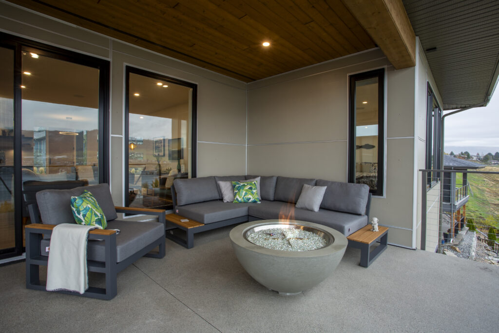 Outdoor seating area with a sectional sofa, fire pit, and view of the surroundings.