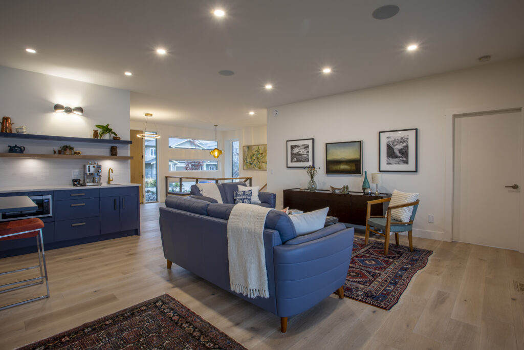 Living room with blue sofas, rug, and large sliding glass doors leading to a patio.