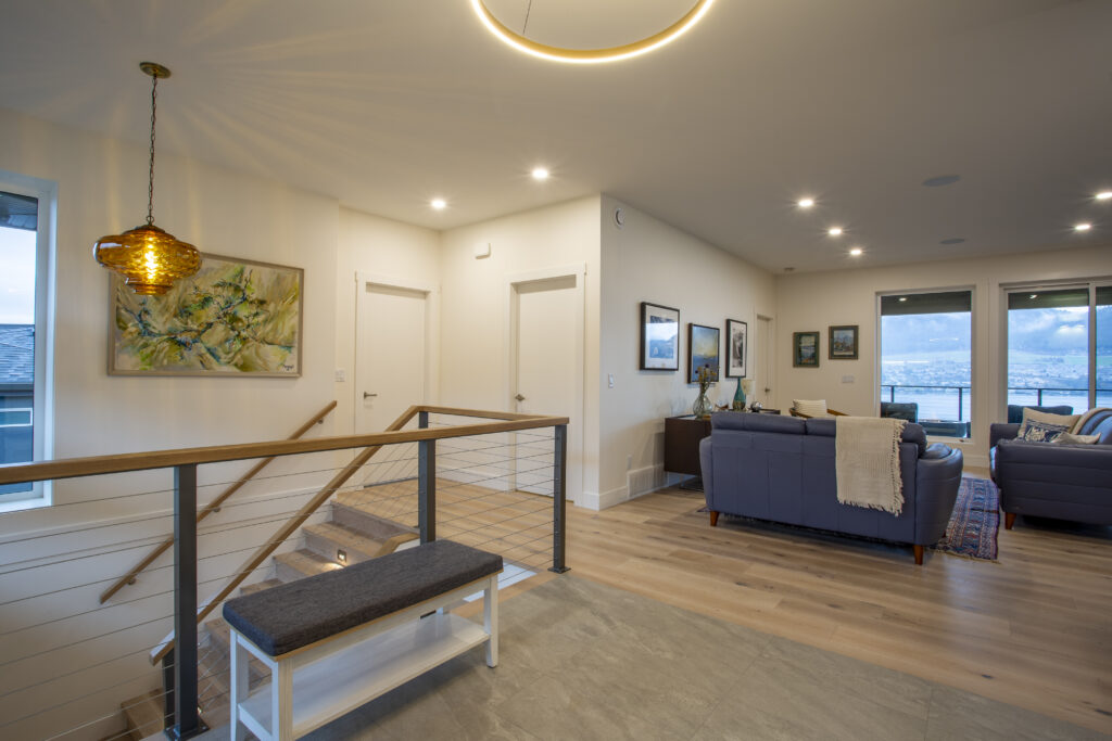 Open hallway leading to a living area with blue sofas and modern decor.