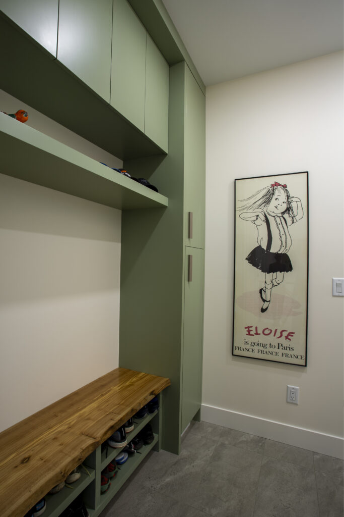 Hallway with green built-in storage and framed artwork of a dancing girl.