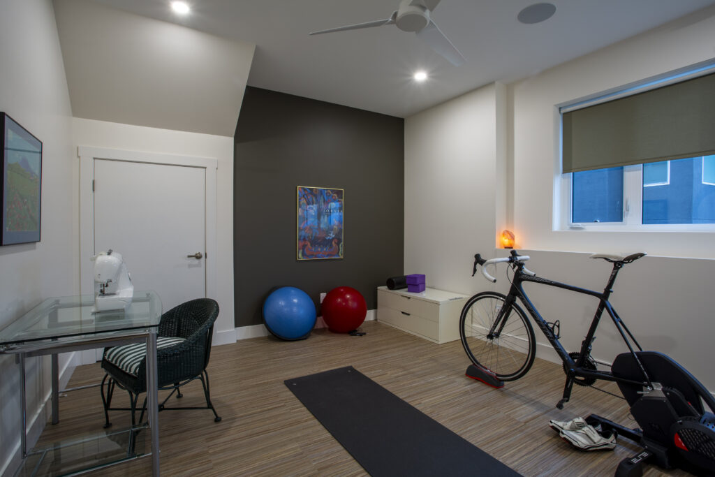 Home gym with yoga mat, exercise equipment, and colorful exercise balls.