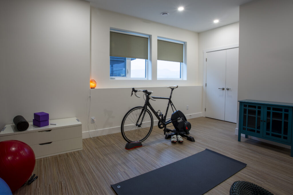 Home gym with yoga mat, exercise equipment, and colorful exercise balls.