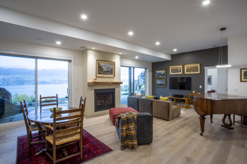 Living room with a fireplace, cozy seating, and large windows offering lake views.
