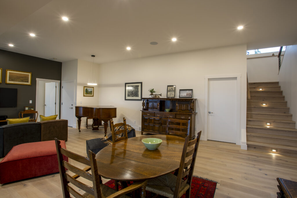 Living area with a grand piano, sectional sofa, and modern decor.
