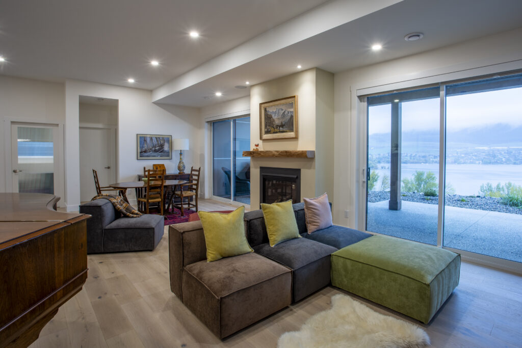 Living area with a grand piano, sectional sofa, and modern decor.