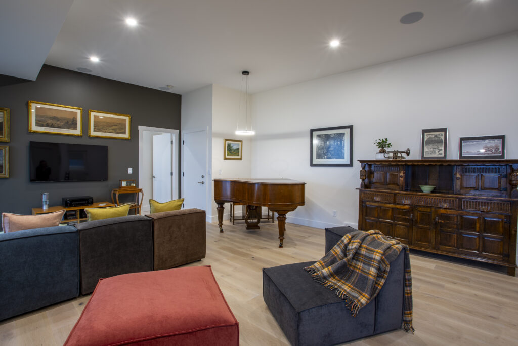 Entertainment room featuring a grand piano, comfortable seating, and wall art.