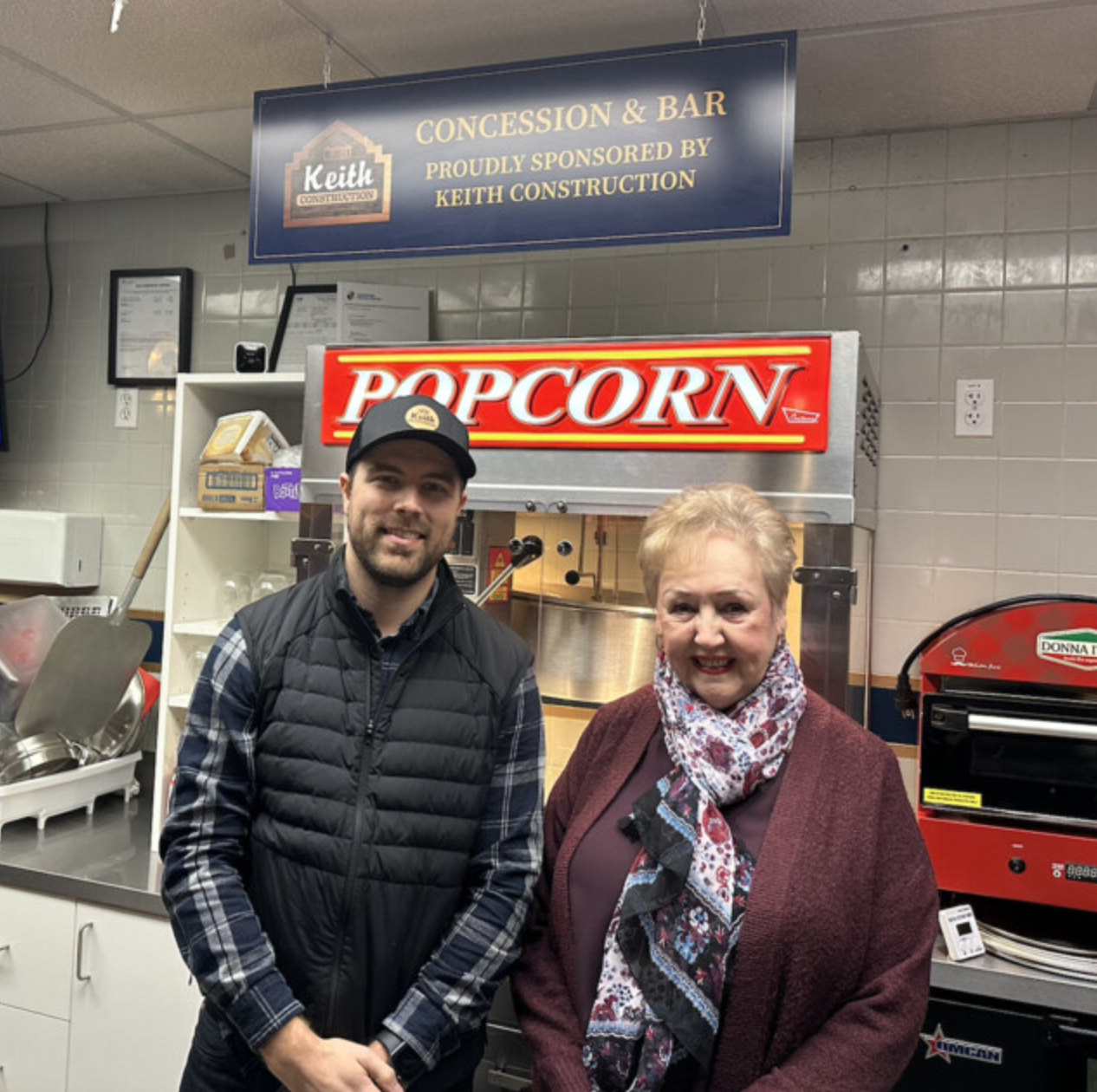 Modern custom home with wood and dark metal siding, large windows, and a spacious driveway, built by Keith Construction in Coldstream, BC.
