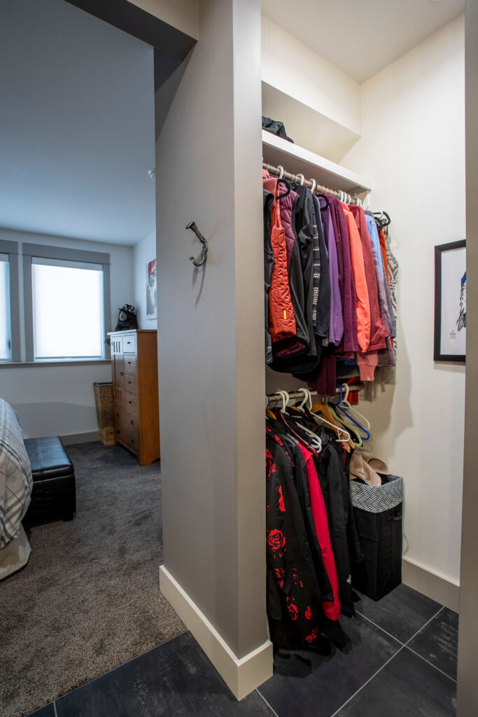 Walk-in closet with clothing racks and view into the bedroom.