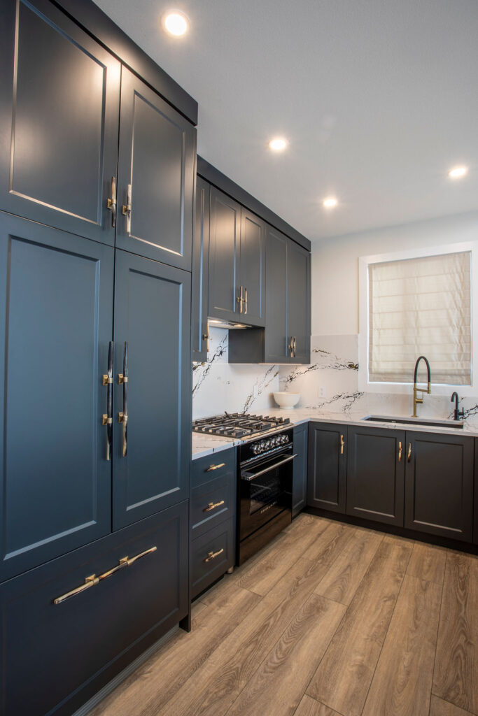 Image of the kitchen area with a gas range, built-in cabinets, and marble backsplash.