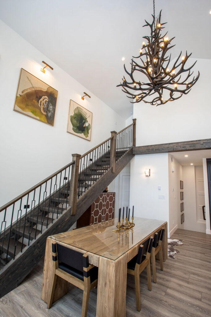 Image of a high-ceiling living area with modern decor and large artwork above the stairs.