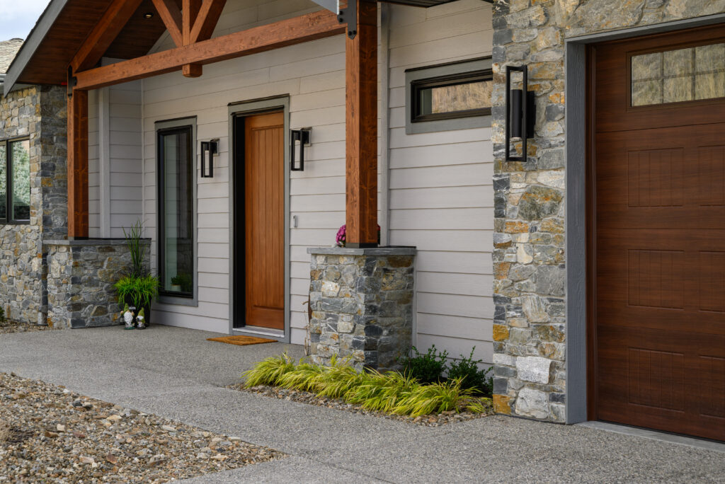 Custom home entrance with wood and stone accents in Adventure Bay, Vernon.