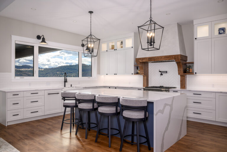 Bright open-concept kitchen with a large island and pendant lighting in Vernon custom home.